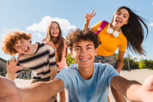 selfie shot of crazy young people friends college students school pupils classmates teenagers having fun together spend time summer weekend in skate park outside urban street. friendship concept